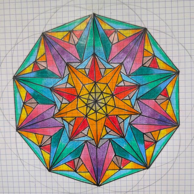 Coloured-pencil mandala on grid paper: a ten-sided star built from triangles in blue, turquoise, purple, red, orange and yellow, with a pencil construction circle around it.