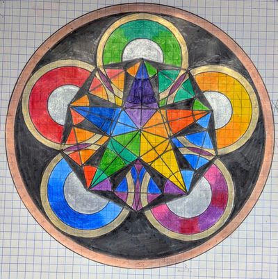 Hand-drawn mandala on grid paper: a rainbow-coloured five-pointed star in the middle of five rings in red, yellow, green, blue and purple with silver inner circles, all framed by a black and copper ring.